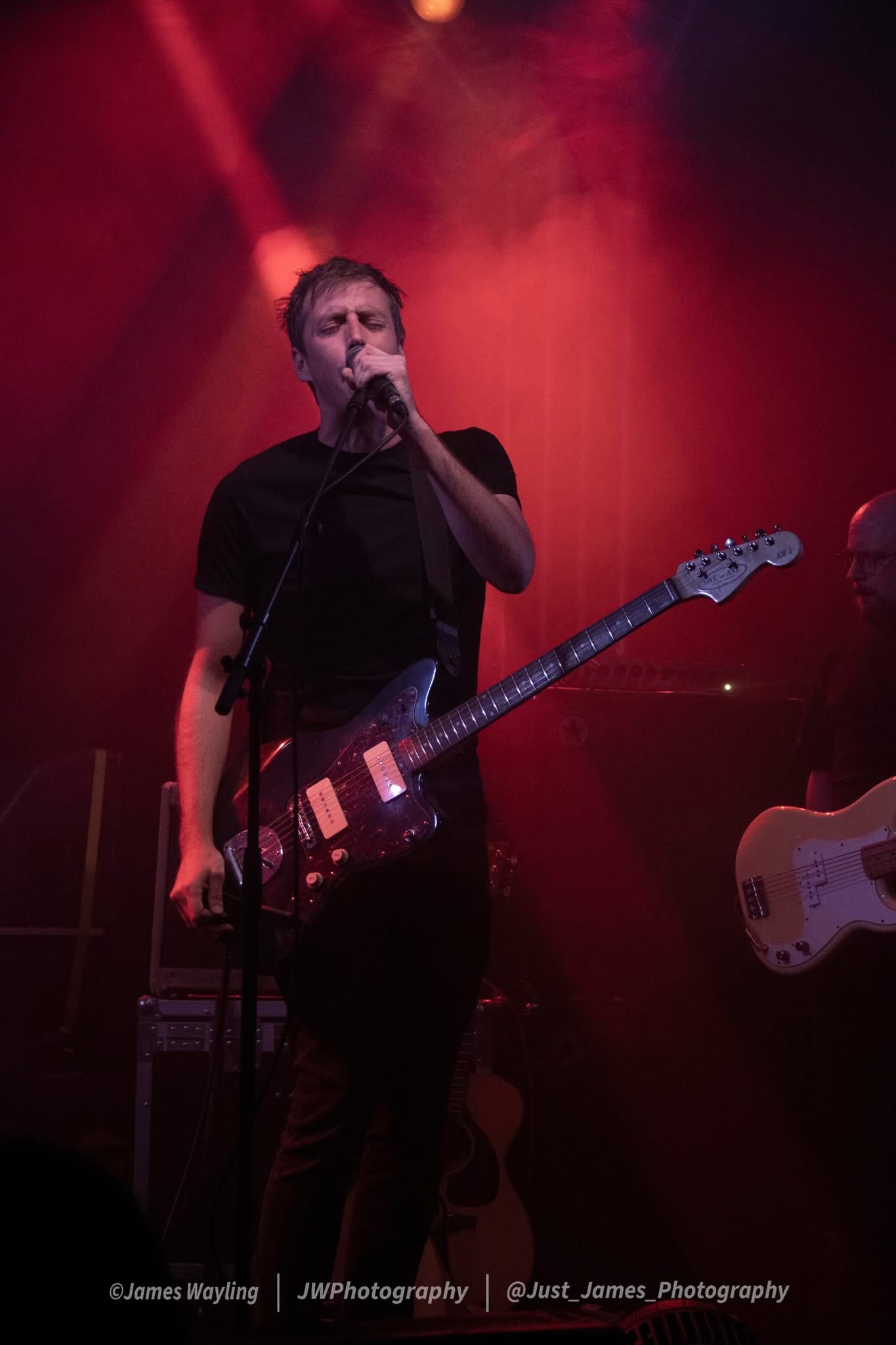 Francis vocalist performing under deep red stage lighting