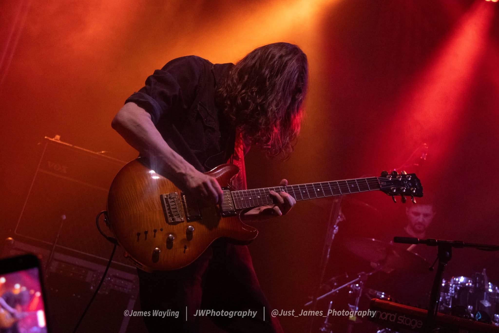 Francis lead guitarist performing under warm stage lighting